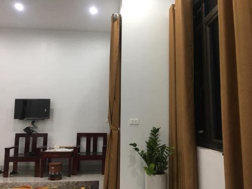 Una puerta a una habitación con TV y una planta en Nhà Nghỉ Cu Tí, en Bản Cong Na