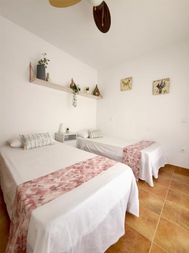 two beds in a room with white walls at Casa en el valle del tietar in Lanzahita