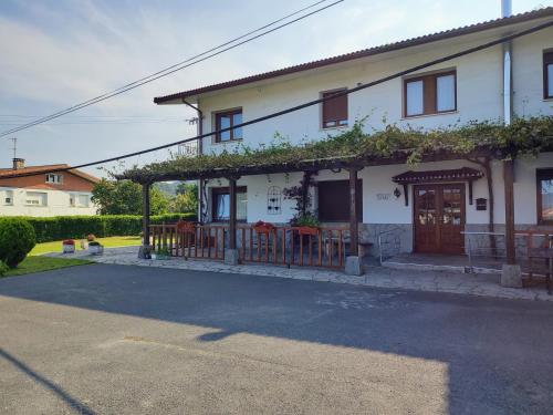 a white house with an ivy covered porch at Atxispe Etxea Casa Rural in Laukiz