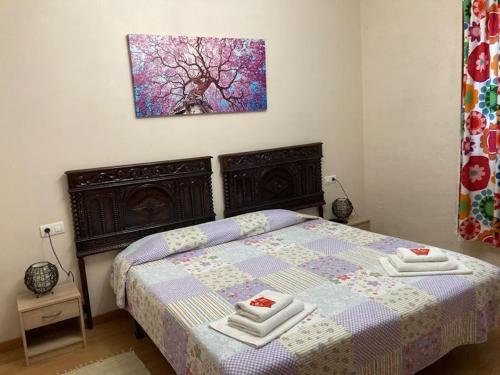 a bedroom with a bed with two towels on it at Atxispe Etxea Casa Rural in Laukiz