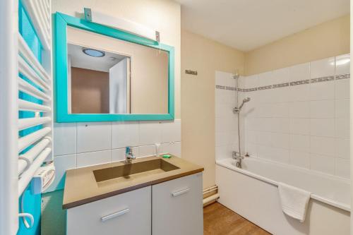 La salle de bains est pourvue d'un lavabo, d'un miroir et d'une baignoire. dans l'établissement Residence Pierre & Vacances Port Guillaume, à Dives-sur-Mer