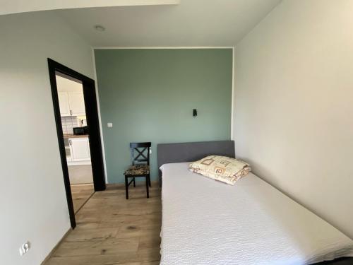 a bedroom with a white bed and a mirror at Zajazd Tadeo in Pietrzykowice