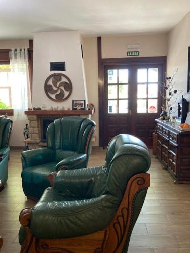 a living room with a leather couch and chairs at Atxispe Etxea Casa Rural in Laukiz