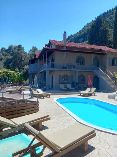a villa with a swimming pool and a house at Seven Keys Luxury Suites in Achílleion