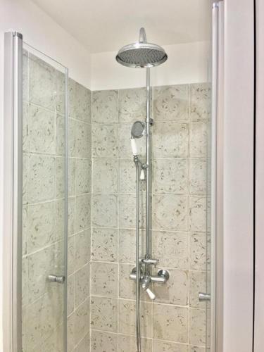 une douche avec une porte vitrée dans une salle de bain dans l'établissement Petit cocoon Aixois, à Aix-en-Provence