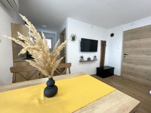 a room with a table with a vase on it at Apartments and rooms pri Bašlju in Cerkno
