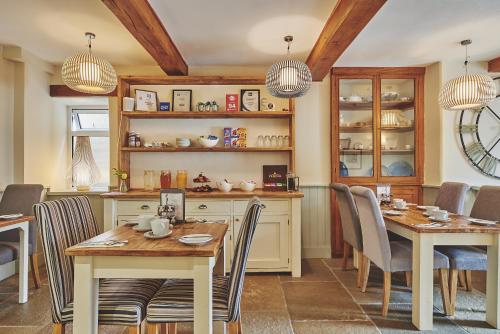 uma cozinha e sala de jantar com duas mesas e cadeiras em The Lansdowne Guest House em Bourton on the Water