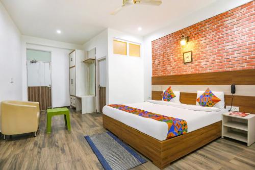a bedroom with a bed and a brick wall at FabHotel Aravali Suites in Gurgaon