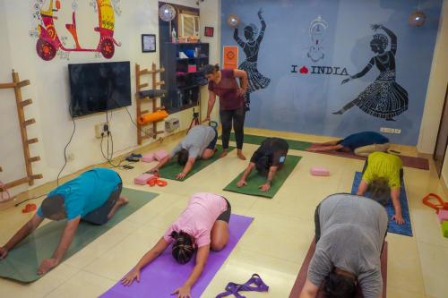 a group of people doing yoga in a room at AmigosIndia in New Delhi