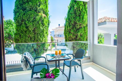 a balcony with a table and chairs and trees at Acrotel Lily Ann Village in Nikiti