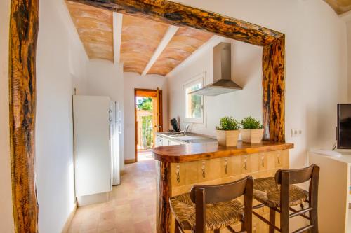 cocina con encimera con sillas y nevera en Ideal Property Mallorca - Sol de Mallorca 1, en Cala Mesquida