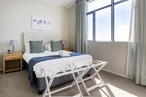 a white bedroom with a bed and a window at Axis Luxury Apartments by Century City Hotels in Cape Town