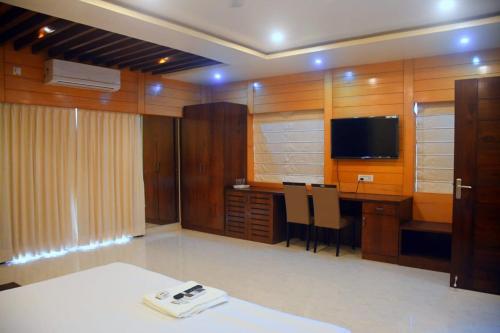 a room with a desk and a television in a room at PRINCE PALACE in Jhārgrām
