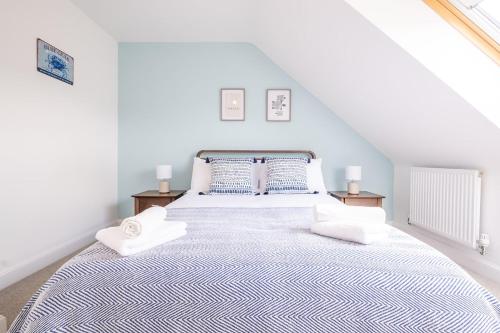 a white bedroom with a large bed with two night stands at Stunning Family Friendly Home - Free Parking in Bedford