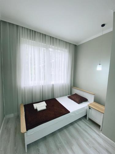 1 dormitorio con 1 cama grande y ventana en Квартира на берегу Черного моря, en Sukhum