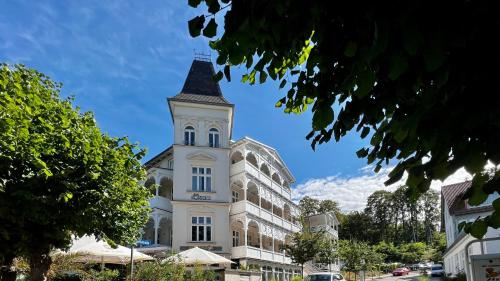 ein hohes weißes Gebäude mit einem Turm in der Unterkunft Villa Sonneck – Wohnung 15 in Ostseebad Sellin