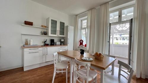 eine Küche mit einem Tisch und Stühlen sowie ein Esszimmer in der Unterkunft Villa Sonneck – Wohnung 15 in Ostseebad Sellin