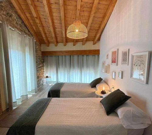 a hotel room with two beds and a chandelier at Encuentra el norte en la Casa del buen camino in Oreña