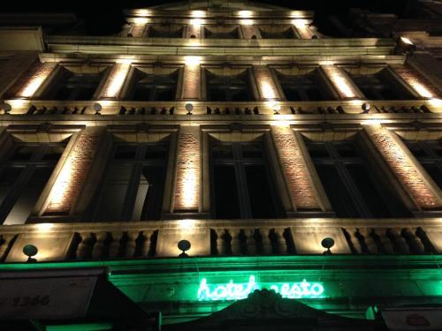 a building with a neon sign on it at night at Hotel Mille Colonnes in Leuven