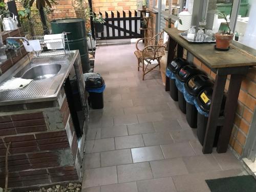 a kitchen with a sink and a counter with a table at Casa Dona Hilda Blumenau in Blumenau
