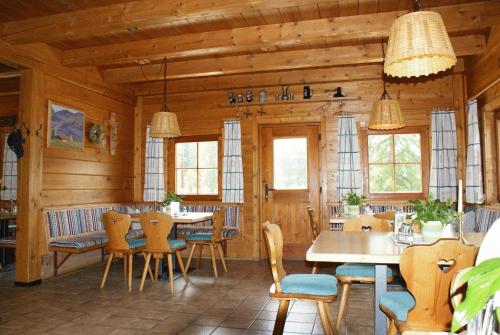 een eetkamer met houten muren en tafels en stoelen bij Gasthaus Oberweissen-Hittl in Sankt Jakob in Defereggen