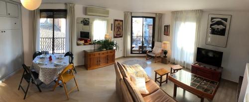 sala de estar con mesa y sofá en Loft acogedor con terraza y parking en el centro, en Huesca