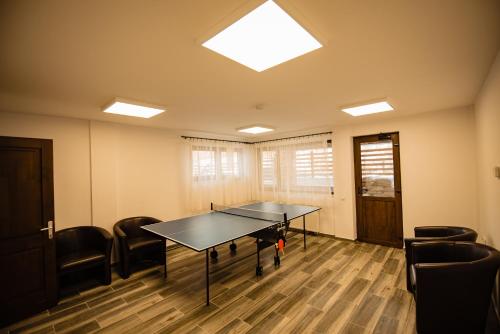 a room with a ping pong table and chairs at Agropensiunea turistică La Rusu in Rodna