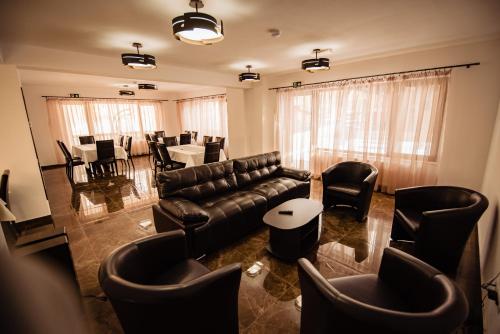 a living room with a couch and tables and chairs at Agropensiunea turistică La Rusu in Rodna