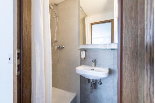 La salle de bains est pourvue d'un lavabo et d'un miroir. dans l'établissement theAmbassador Hotel I Essen City, à Essen