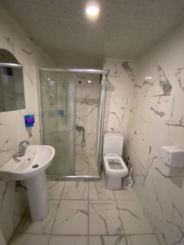 een badkamer met een douche, een wastafel en een toilet bij dagkent plus suit in Tokat