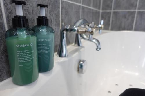 a bathroom sink with two bottles of soap on it at Largee 5 Bed House, Sleeps 10 Near NEC, BHX, HS2 in Birmingham