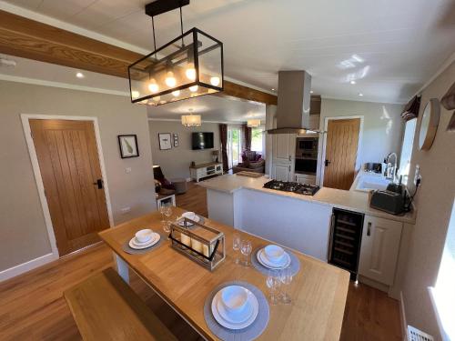 a kitchen and living room with a table with plates on it at Hollicarrs - Dragonfly Lodge in York