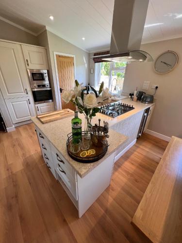 a kitchen with a counter with flowers on it at Hollicarrs - Dragonfly Lodge in York