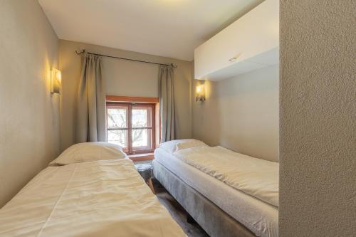 two beds in a small room with a window at Das Schmiedhaus in Kaprun