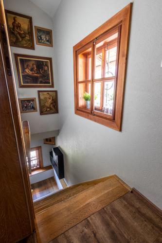 a room with a staircase with a window and some pictures at Das Schmiedhaus in Kaprun