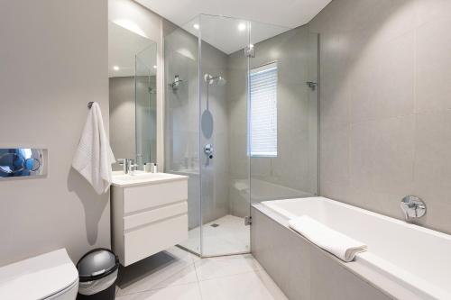 Axis Luxury Apartments by Century City Hotels في كيب تاون: حمام مع حوض ومرحاض ومغسلة