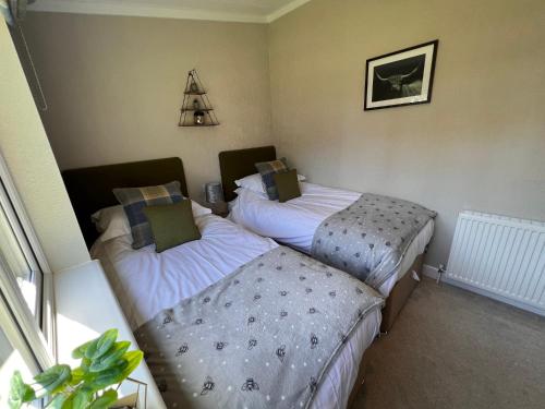 two twin beds in a room with a window at Hollicarrs - Dragonfly Lodge in York
