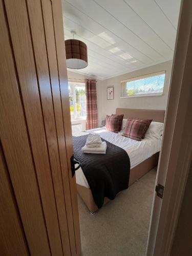 a small bedroom with a bed and a window at Hollicarrs - Dragonfly Lodge in York