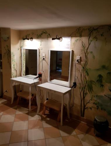 a room with two tables and mirrors on the wall at ZibiSPA pokój nr 3 in Malbork