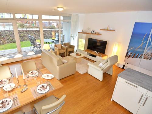 a living room with a table and chairs and a television at DünenResort Binz - Fewo 04 "Strandperle" in Binz