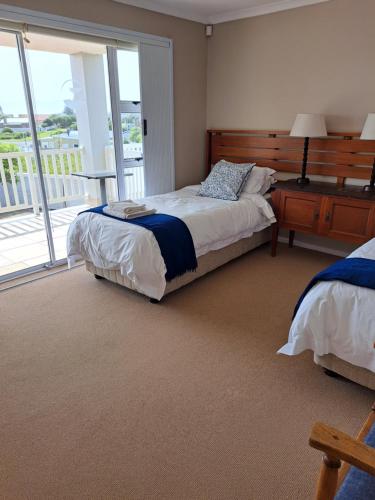 a bedroom with two beds and a large window at Bay Haven in Gansbaai