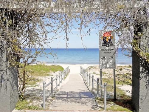 ビンツにあるDünenResort Binz - Fewo 04 "Strandperle"の看板のある海岸へと続く小道