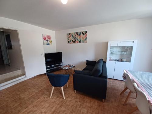 un salon avec un canapé et une télévision dans l'établissement GITE RURAL CHATAIGNERAIE CANTALIENNE, à Saint-Antoine