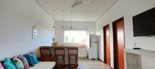 a living room with a couch and a kitchen at Sirena Village in São Miguel do Gostoso