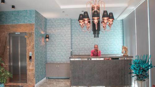 a man standing at a counter in a hotel lobby at TALLES CITY HOTEL in Konak
