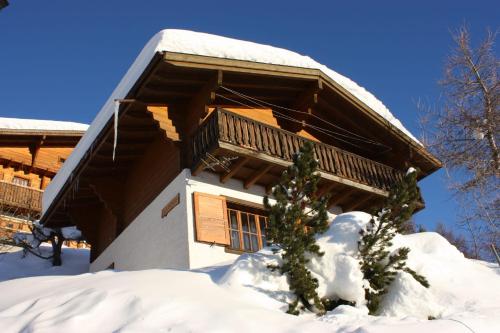 une cabane en rondins avec de la neige devant elle dans l'établissement Chalet Mungg, à Bettmeralp