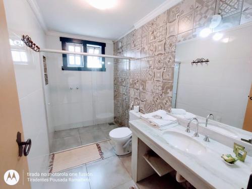 a bathroom with a sink and a toilet and a shower at Tiradentes Pousada Ramalhete in Tiradentes