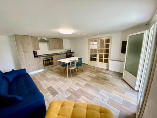 un salon avec un canapé bleu et une cuisine dans l'établissement Au bon temps, à Coutras
