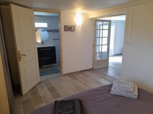 een slaapkamer met een bed en een deur naar een badkamer bij Au bon temps in Coutras