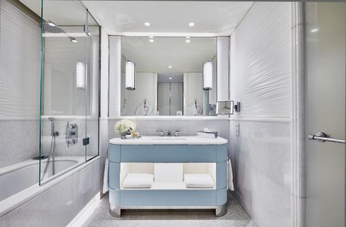 La salle de bains est pourvue d'un lavabo bleu et d'un miroir. dans l'établissement Hôtel Martinez, in The Unbound Collection by Hyatt, à Cannes